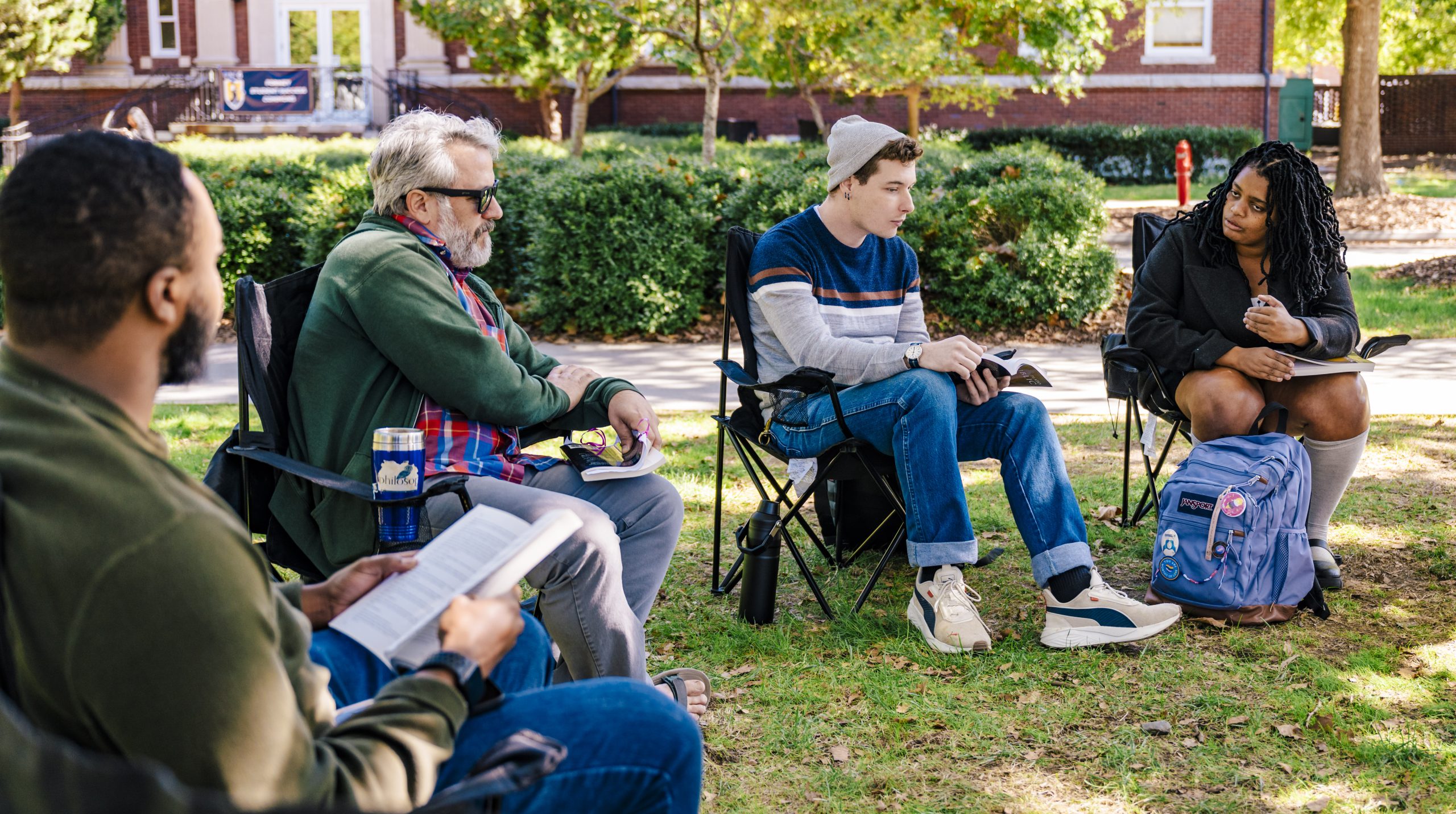 people seated in lawn chairs outside in a semi circle